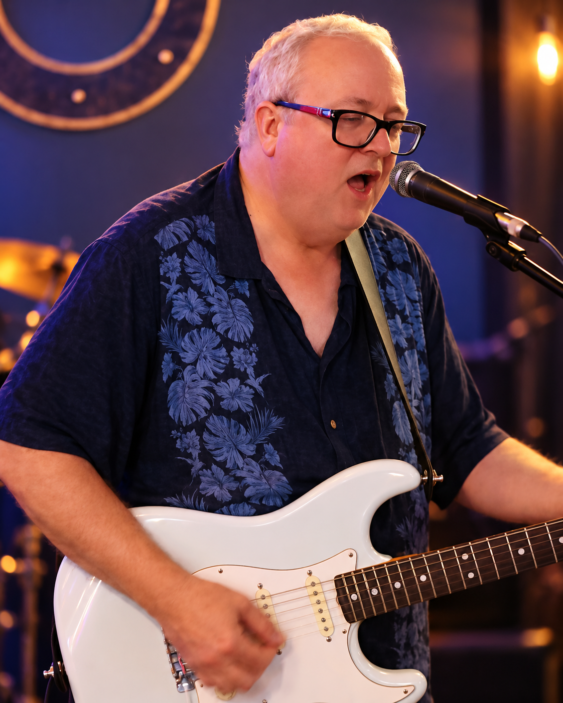 Chuck Vaughn singing and playing a white electric guitar